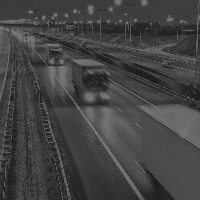 Nocna autostrada z zestawami ciężarowymi w trasie